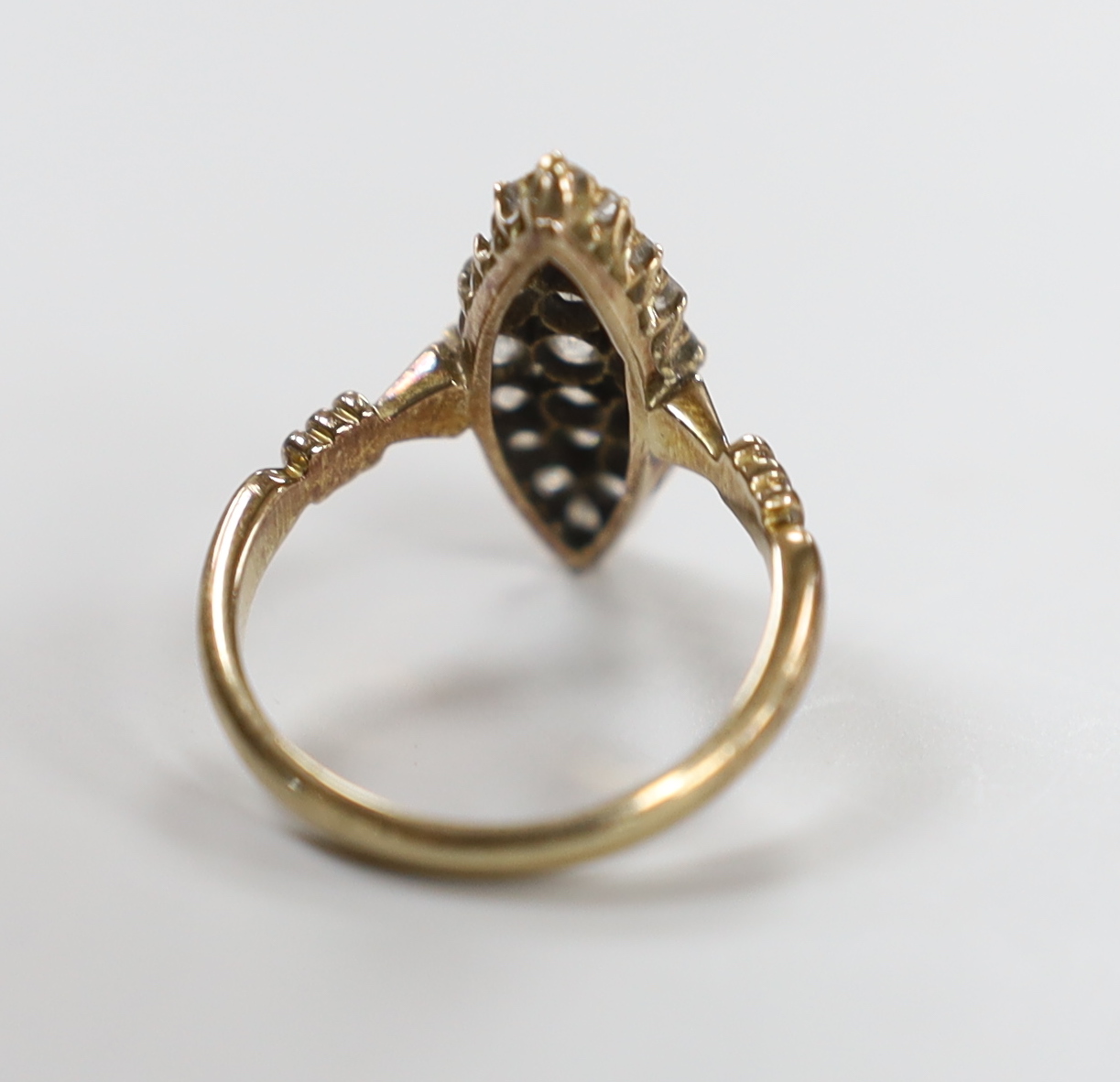 An early 20th century 18ct and diamond cluster set marquise shaped ring (one stone replaced not diamond), size P, gross weight 4.2 grams.
